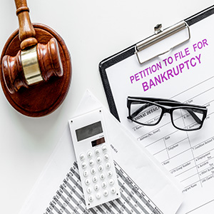 Petition to file for bankruptcy. Empty form ready to fill near calculator and judge gavel on white background top view space for text